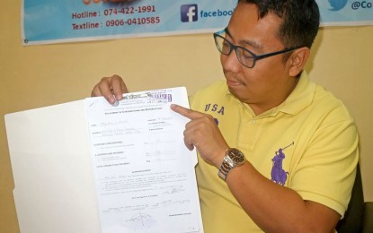 <p><strong>FACING DISQUALIFICATION.</strong> Comelec-Baguio election officer, lawyer Paul John Martin, shows the list of winning candidates in the May barangay and Sangguniang Kabataan election who failed to submit their Statements of Contributions and Expenses (SOCE) on time. All the candidates, whether they lost or won, are required by law to file their SOCEs within 30 days after election day. <em>(Photo by Pamela Mariz Geminiano)</em></p>